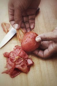 Kreuzförmig einschneiden und kurz kochen: Danach lassen sich Tomaten fast von selbst schälen.